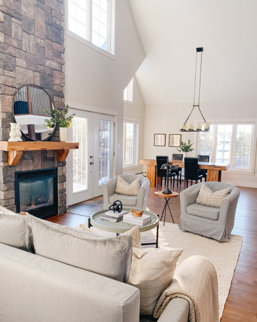 A pic of a living room staged with the focus on the floor to ceiling fireplace using layers and cozy textures to help buyers imagine themselves spending time with family or relaxing in front of the fire after a long day. This room is the second most important room to stage.